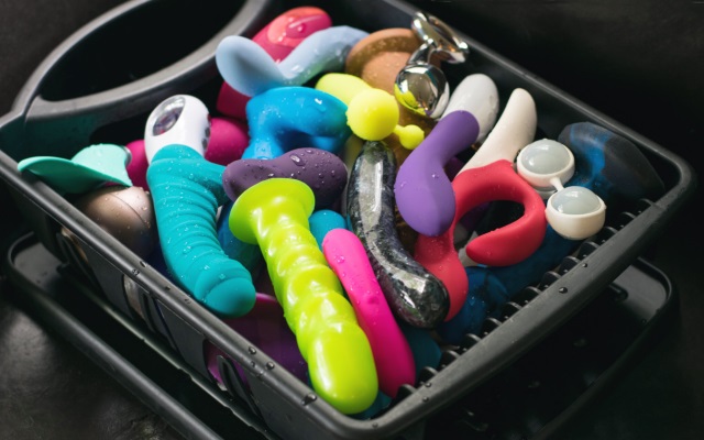 Bin of colorful sex toys many colorful sex toys in a black bin