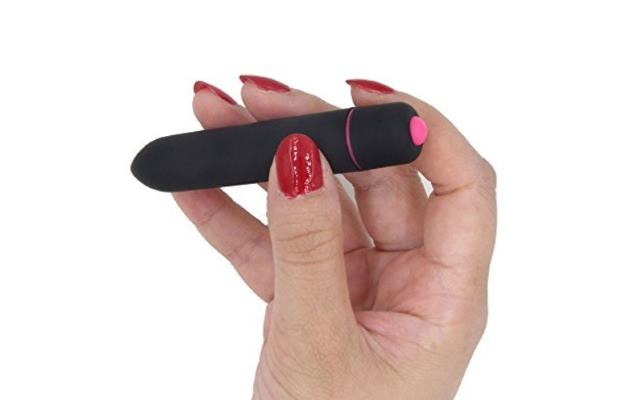 Bullet vibrator in hand Black and pink bullet vibrator held in fingertips of a woman