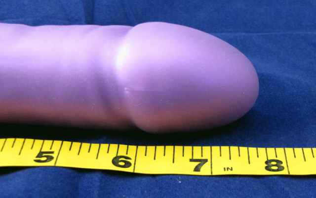 Dildo next to Measuring Tape end of purple dildo lying next to measuring tape showing between 7 to 8 inches
