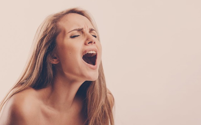 Intense Orgasm Face Blonde woman making intense orgasm face over light brown background
