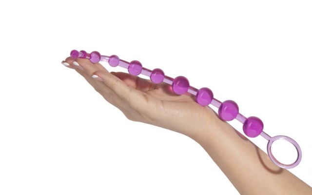 Pink anal beads in hand Luxurious pink anal beads resting in hand of mwoman