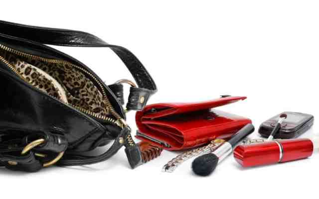 Emptied Purse Contents Empty black leather purse revealing wallet and other beauty accessories