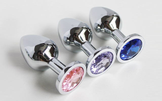 Three stainless steel butt plugs Blue, pink and purple stainless steel butt plugs laying next to each other