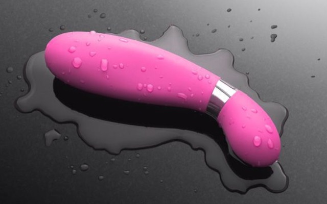 Wet Vibrator Vibrator soaked in water on a black tabletop