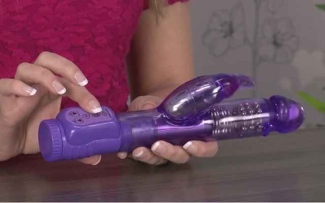 Woman with Rabbit Vibrator Purple rabbit vibrator being held by a woman at a table